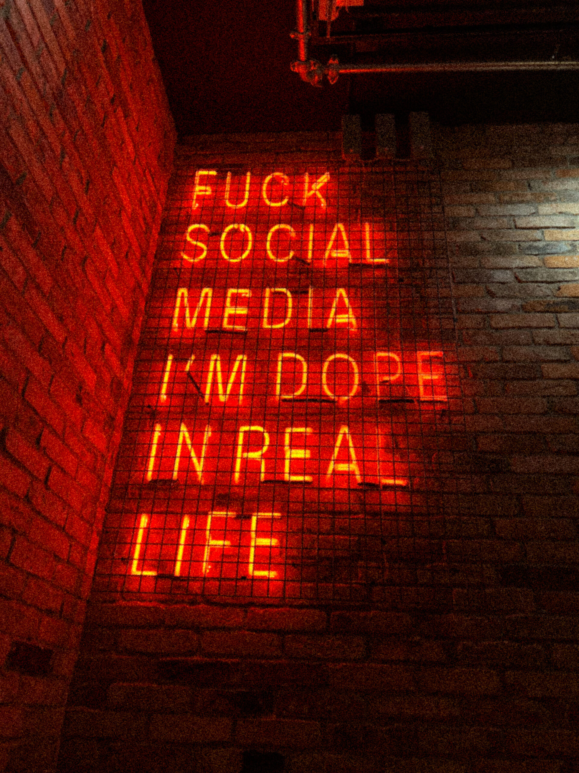 Rotes Neon-Schild mit Social-Media-Statement – unkonventionelle Fotografie mit Attitude.