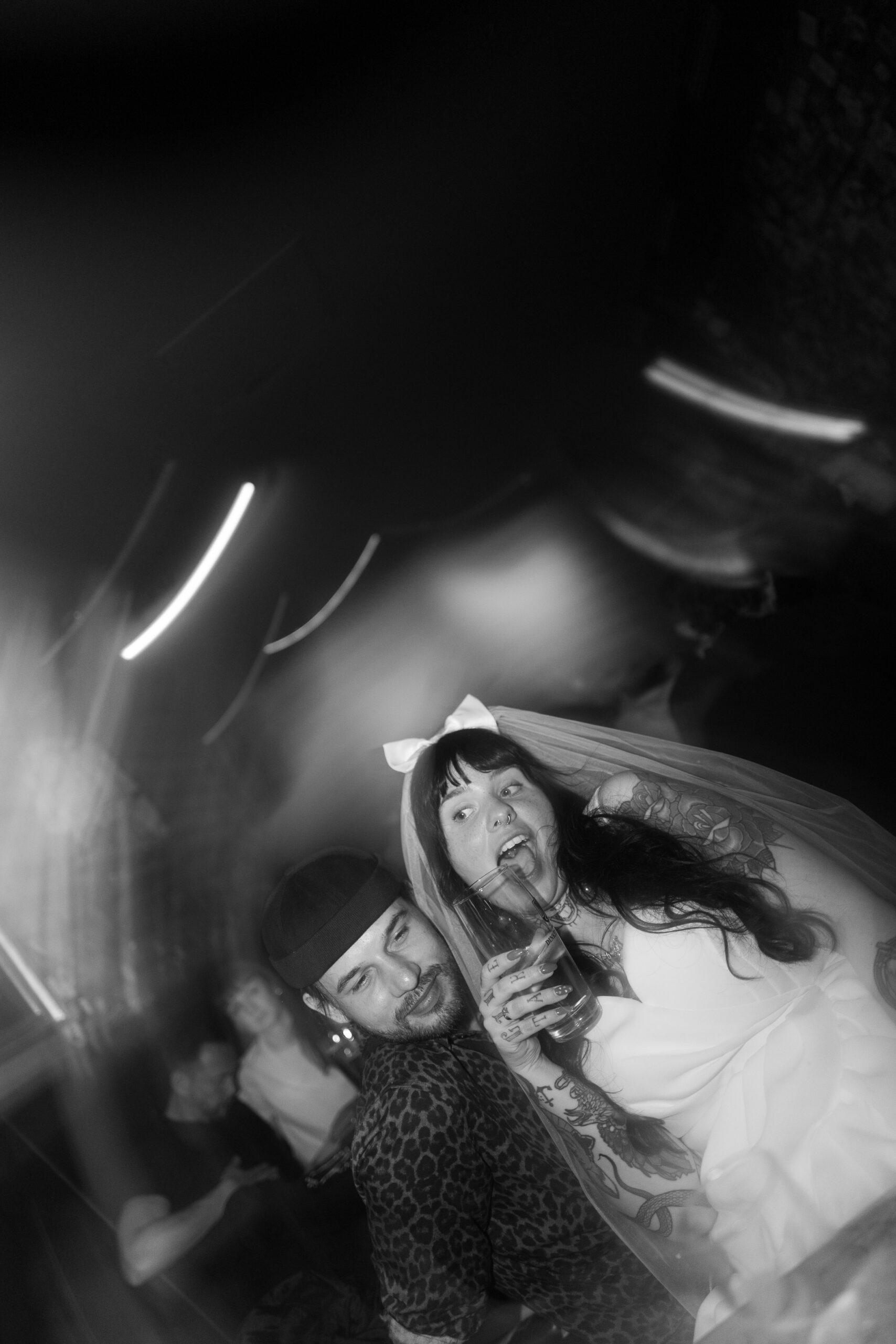 Braut und Bräutigam feiern ausgelassen auf der Hochzeitsparty, verschwommene Bewegungen, echte Energie.