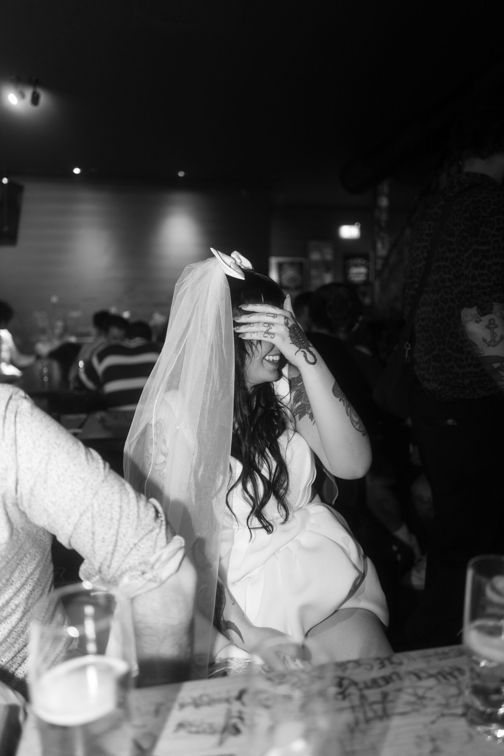 Braut verdeckt ihr Gesicht mit ihrer Hand während der Hochzeitsfeier.