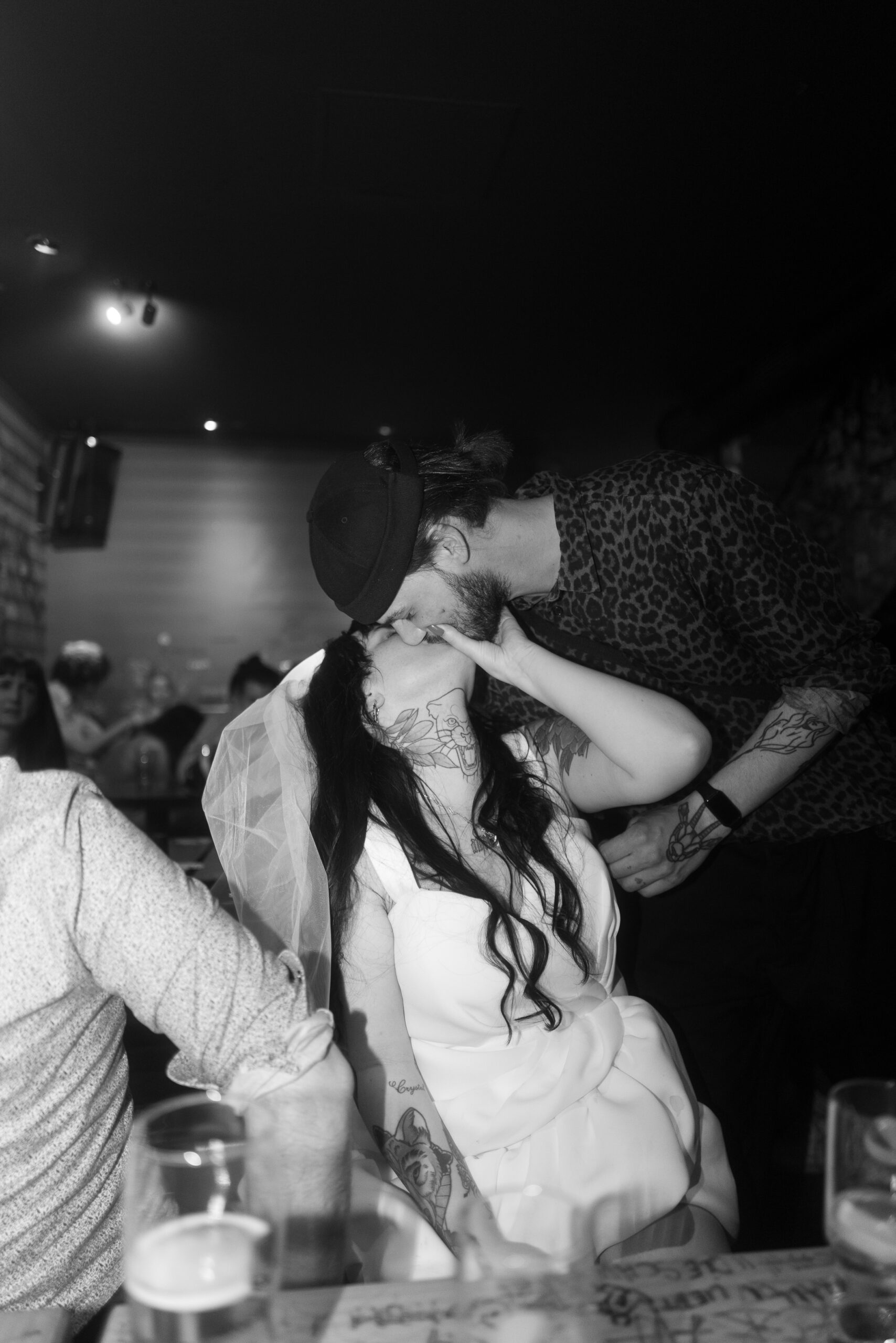 Der Bräutigam flüstert seiner Braut während der Party liebevoll etwas ins Ohr