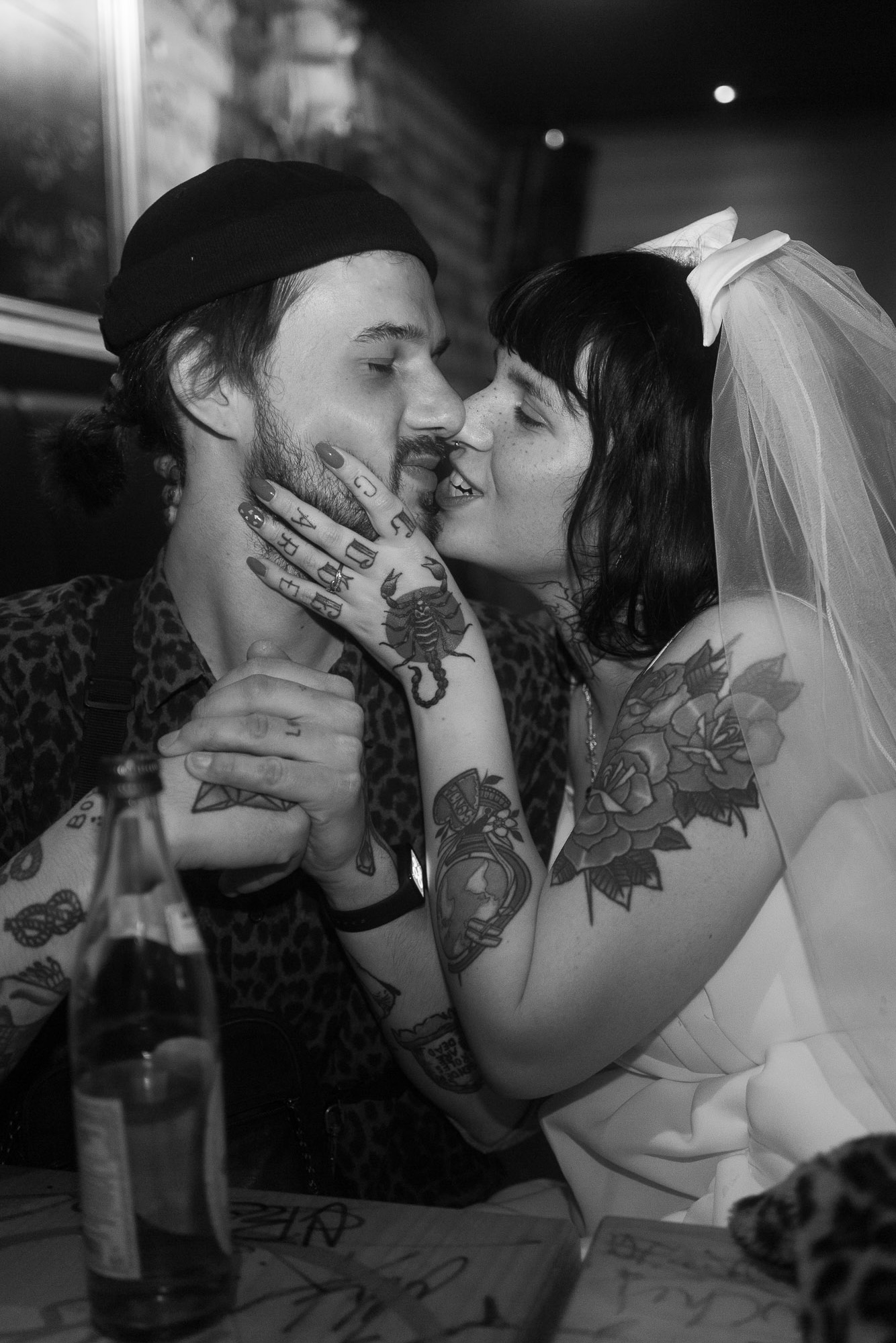 Intimer Moment eines Brautpaares mit Tattoos, unkonventionelle Hochzeitsfotografie mit echten Emotionen.
