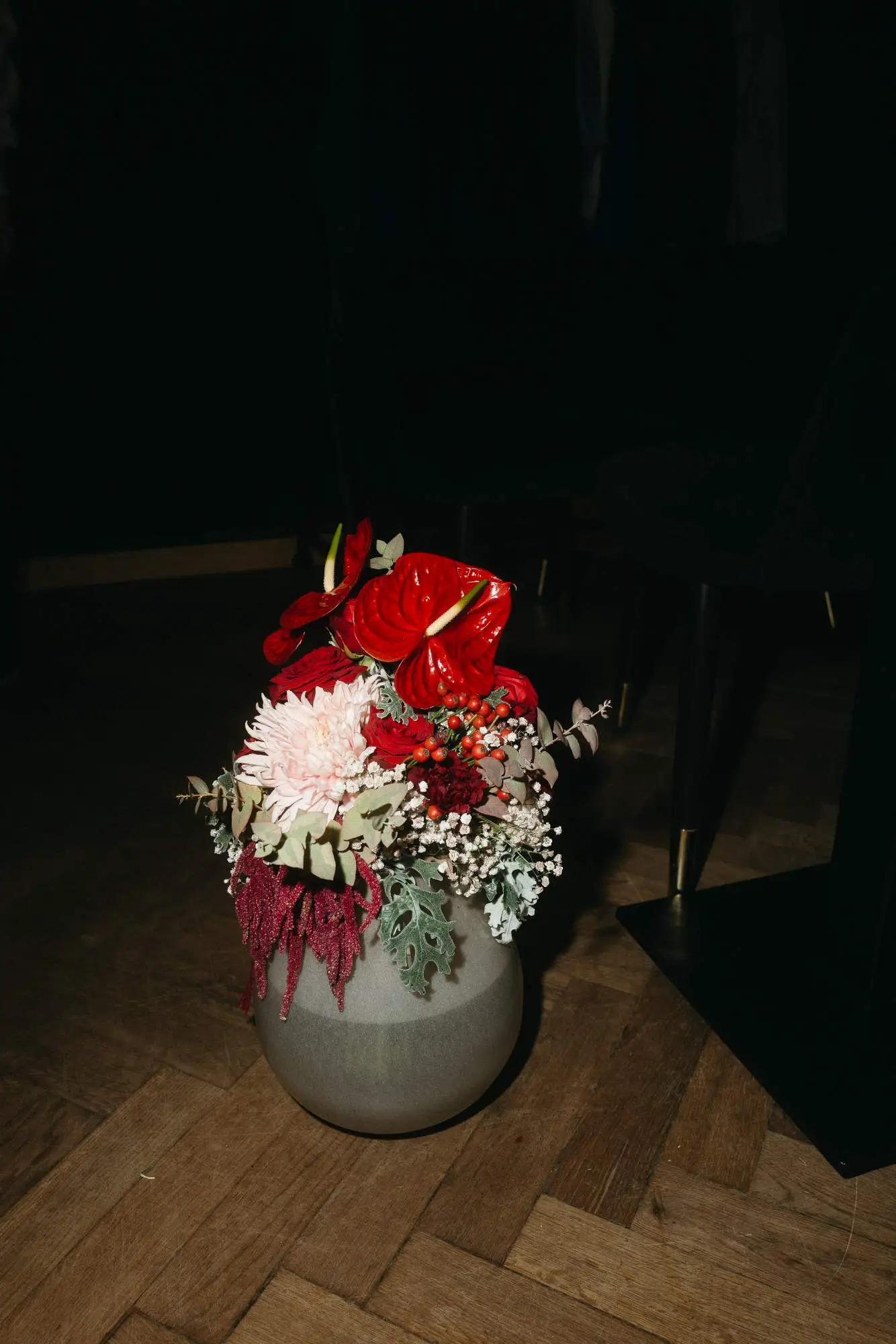 Ein moderner, farbintensiver Blumenstrauß auf Holzboden – echte Momente der Hochzeitsdekoration dokumentarisch eingefangen.