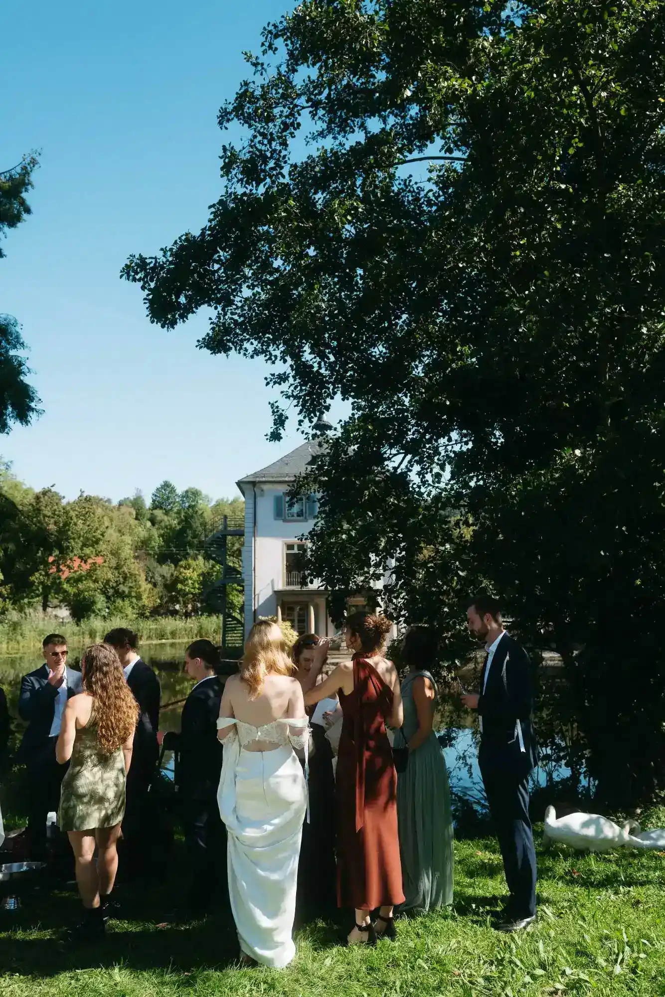 moderne dokumentarische hochzeitsfotografie mit natürlicher interaktion zwischen gästen und braut im freien