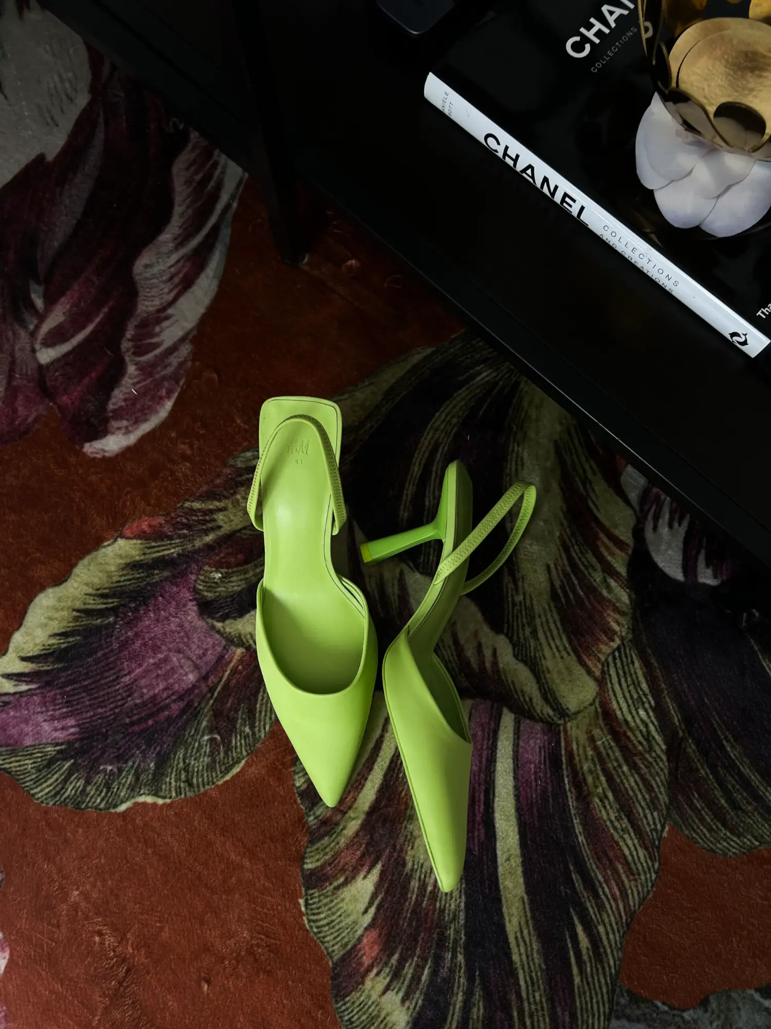 moderne dokumentarische hochzeitsfotografie mit stilvoller detailaufnahme grüner high heels auf gemustertem teppich