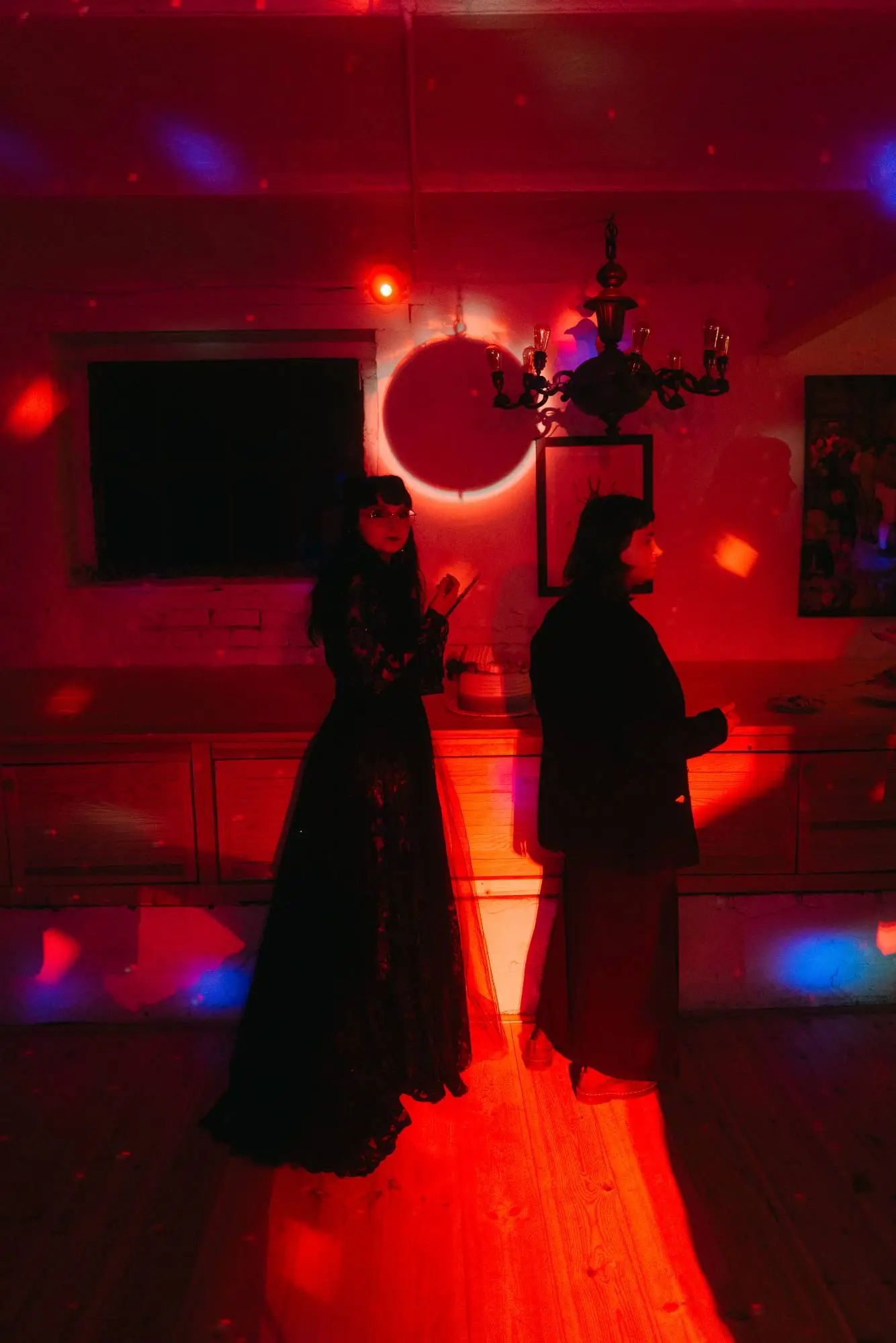 Zwei Gäste bei Hochzeitsfeier in rotem Partylicht – moderne dokumentarische Hochzeitsfotografie mit künstlerischer Atmosphäre