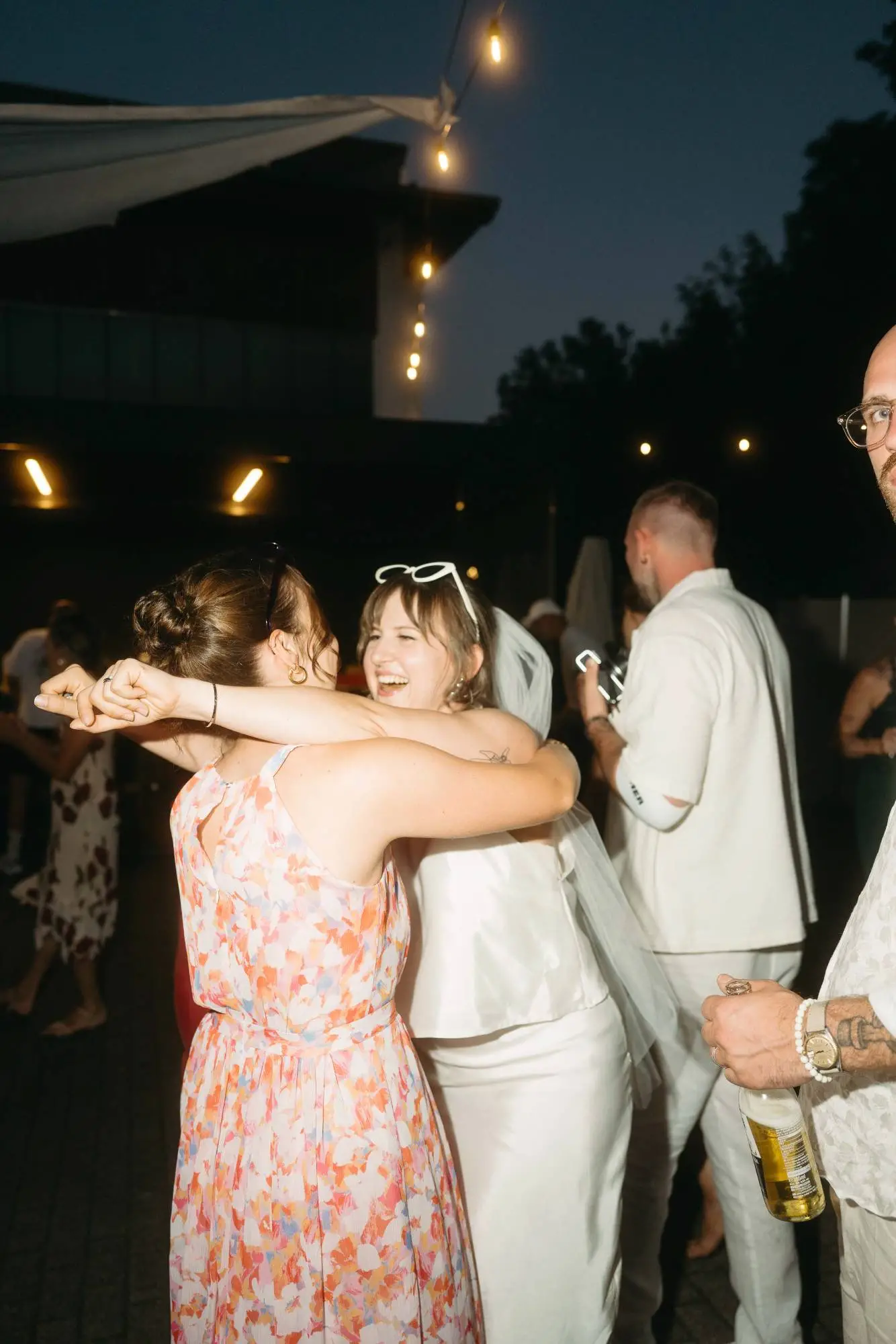 zwei frauen tanzen lachend in der dämmerung – lebendige und emotionale hochzeitsreportage voller bewegung und echtem leben