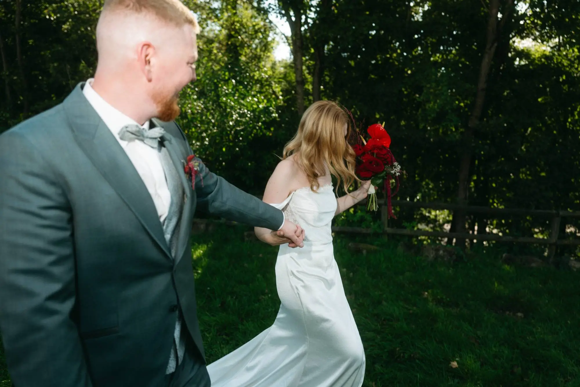 Ein Moment voller Bewegung und Leichtigkeit – das Paar läuft lachend Hand in Hand durch das Grün, mitten ins gemeinsame Abenteuer. Lebendig, ungezwungen und echt.