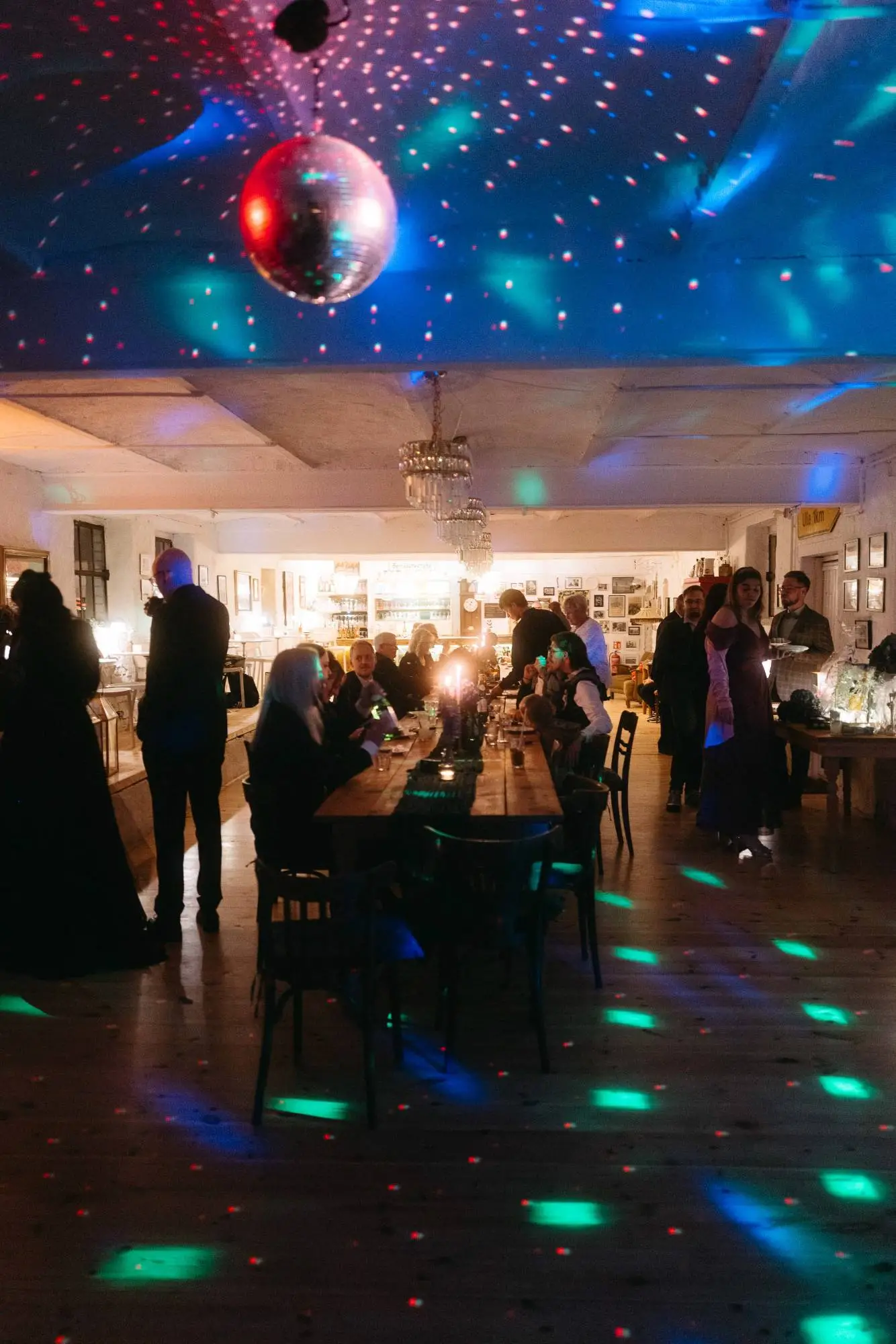 Moderne dokumentarische Hochzeitsfotografie – lebendiger Moment zwischen Menschen bei einer festlichen Hochzeit mit Disco-Kugel und buntem Lichtspiel