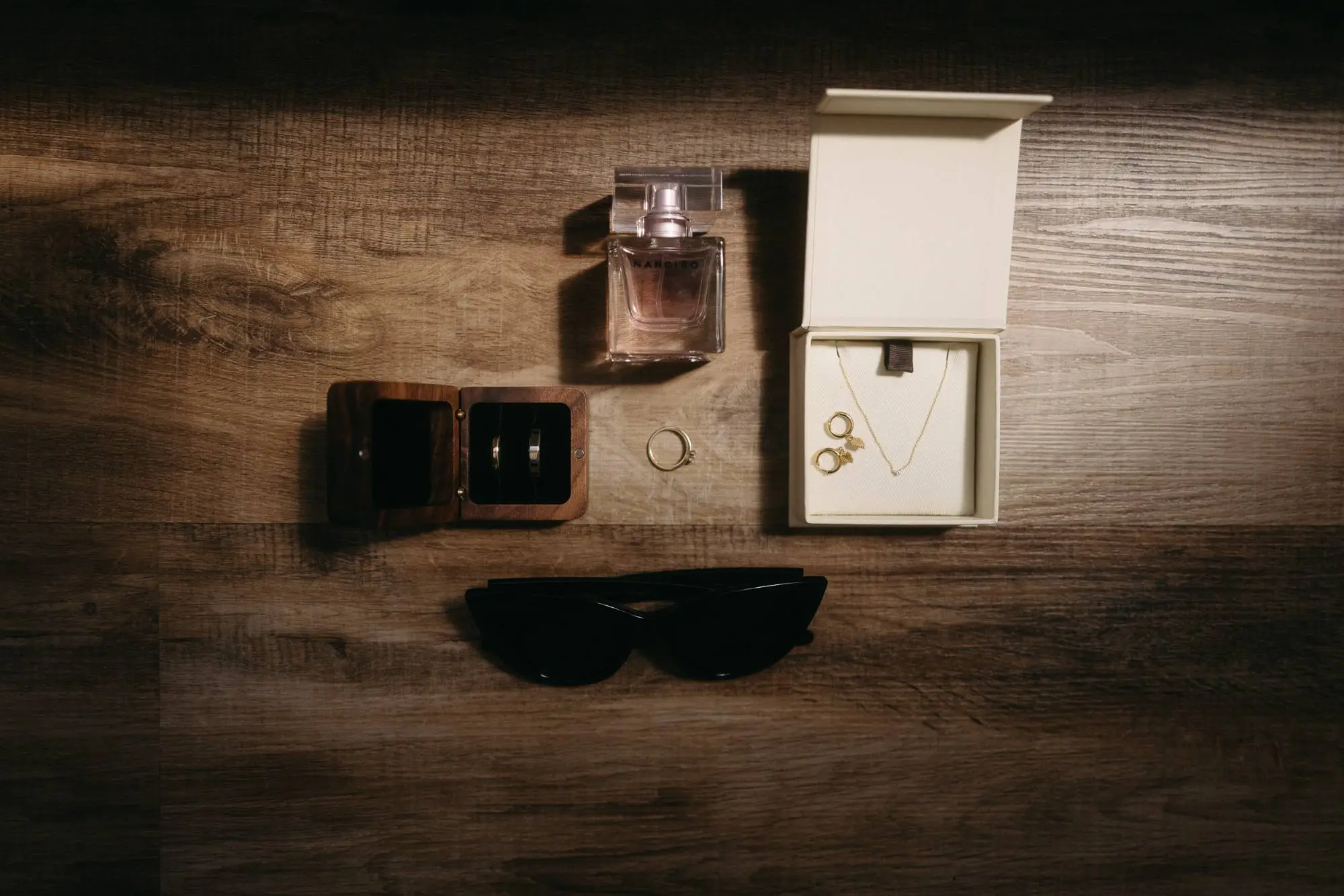 Detailaufnahme von Hochzeitsschmuck, Parfum, Brillen und Accessoires – modern, stilvoll inszeniert, mit dokumentarischem Blick für die kleinen Momente vor der Trauung.