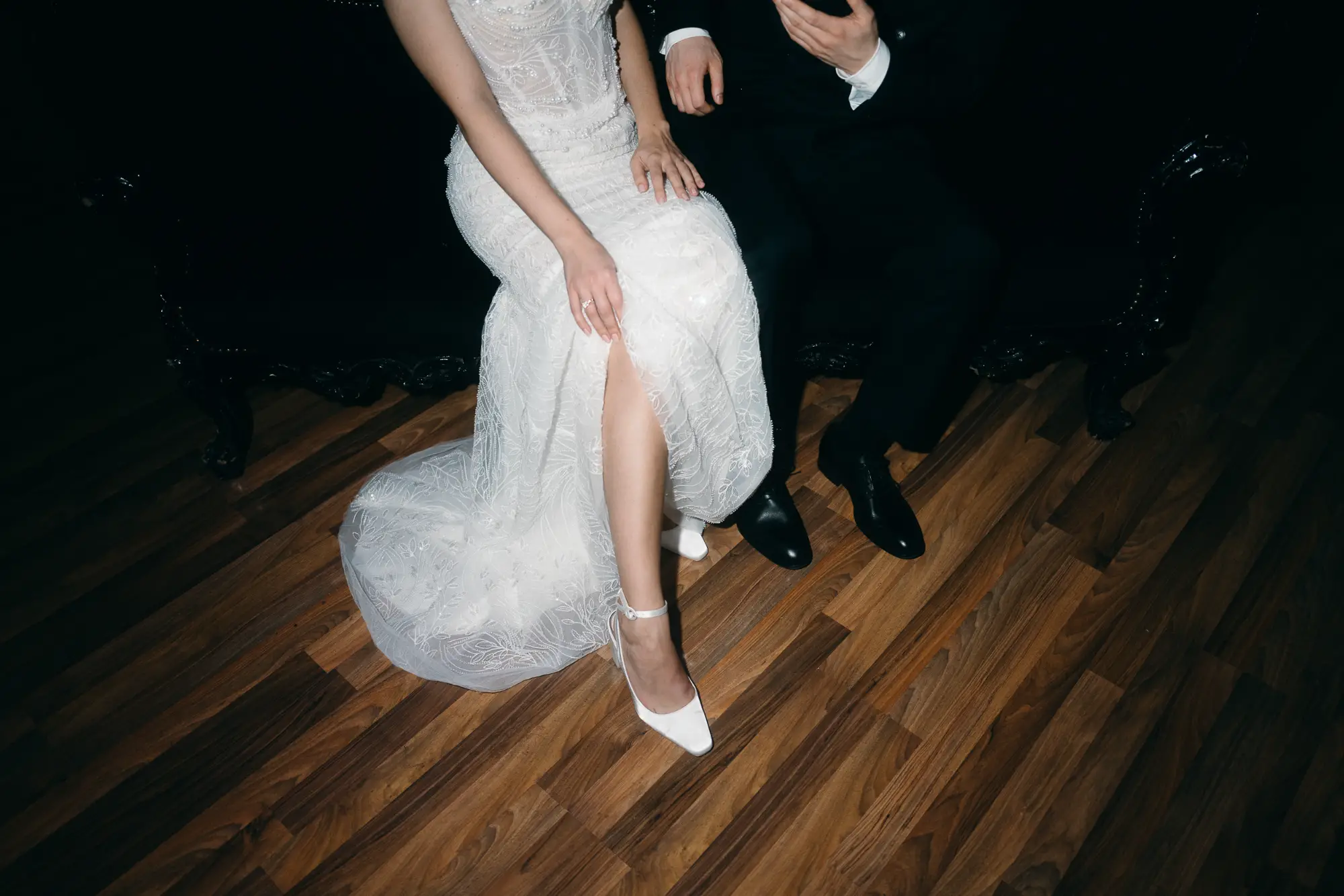 moderne dokumentarische hochzeitsfotografie mit spontanem moment des brautpaares auf dunklem sofa