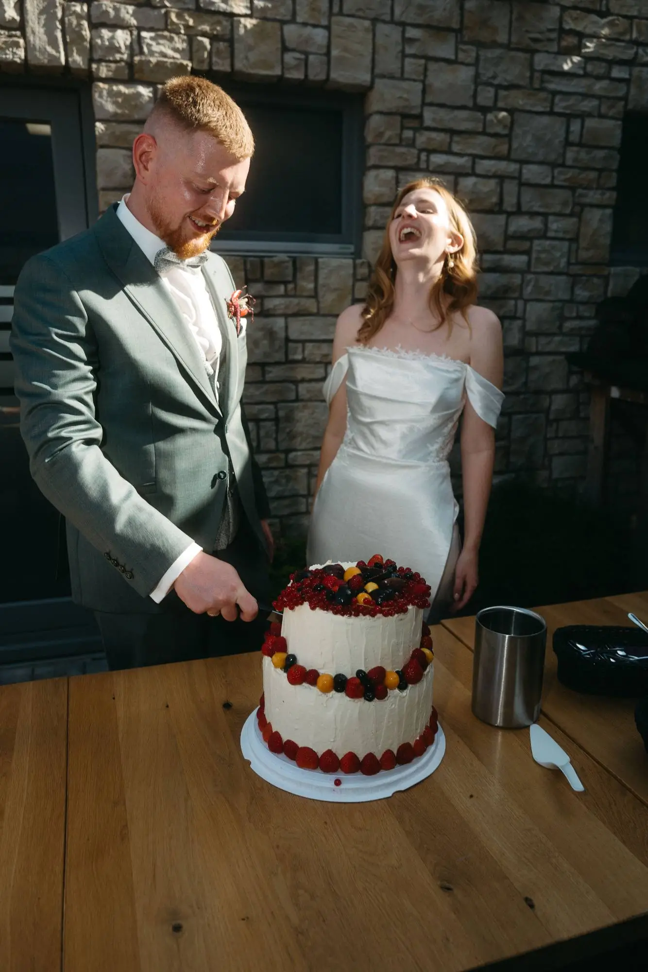 brautpaar schneidet lachend hochzeitstorte an – ungezwungene und moderne hochzeitsreportage mit echten momenten und natürlicher emotion