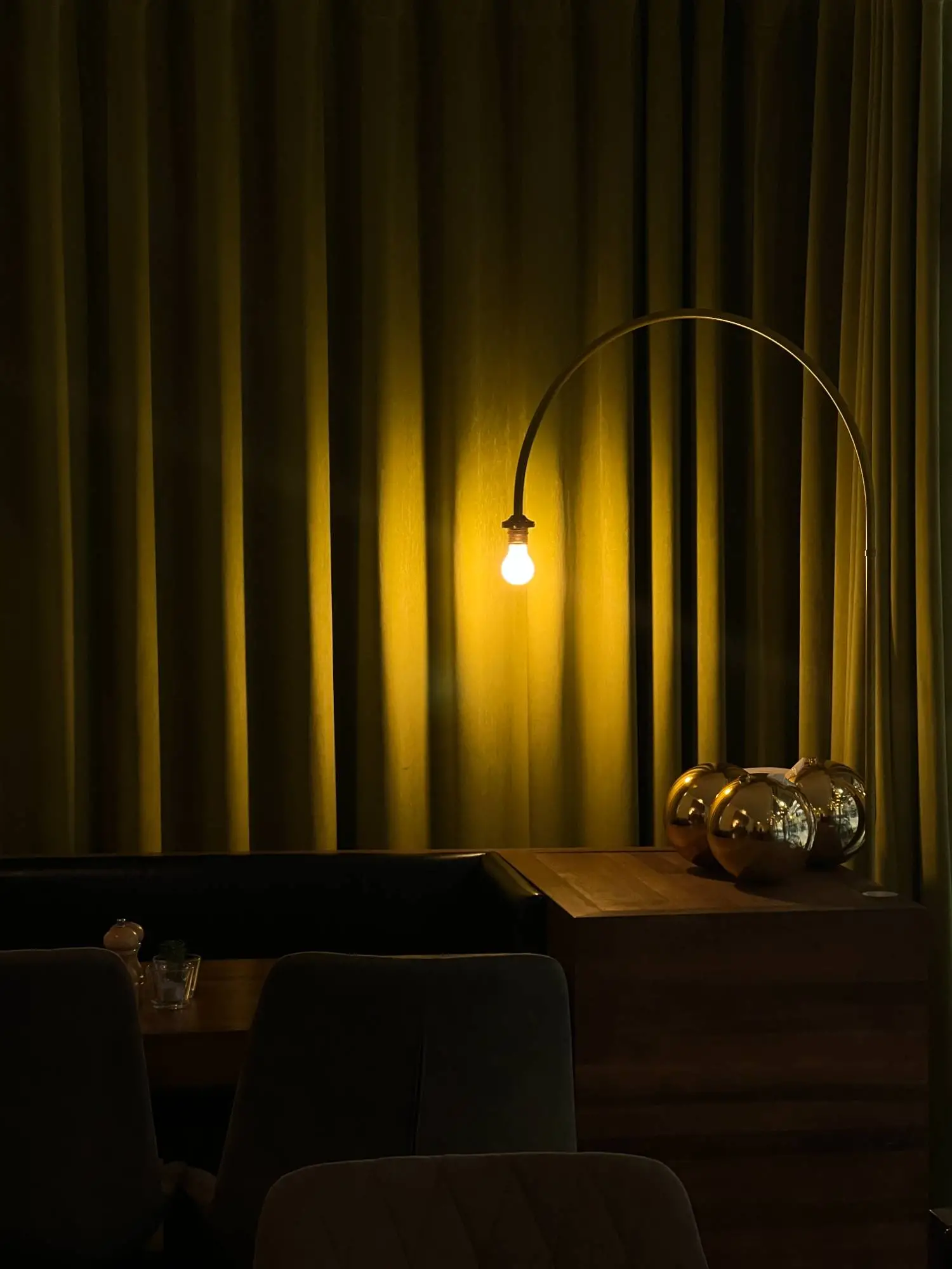 Gedämpftes, warmes Licht einer Glühbirne vor schweren Vorhängen in einer ruhigen Ecke einer Hochzeitslocation.