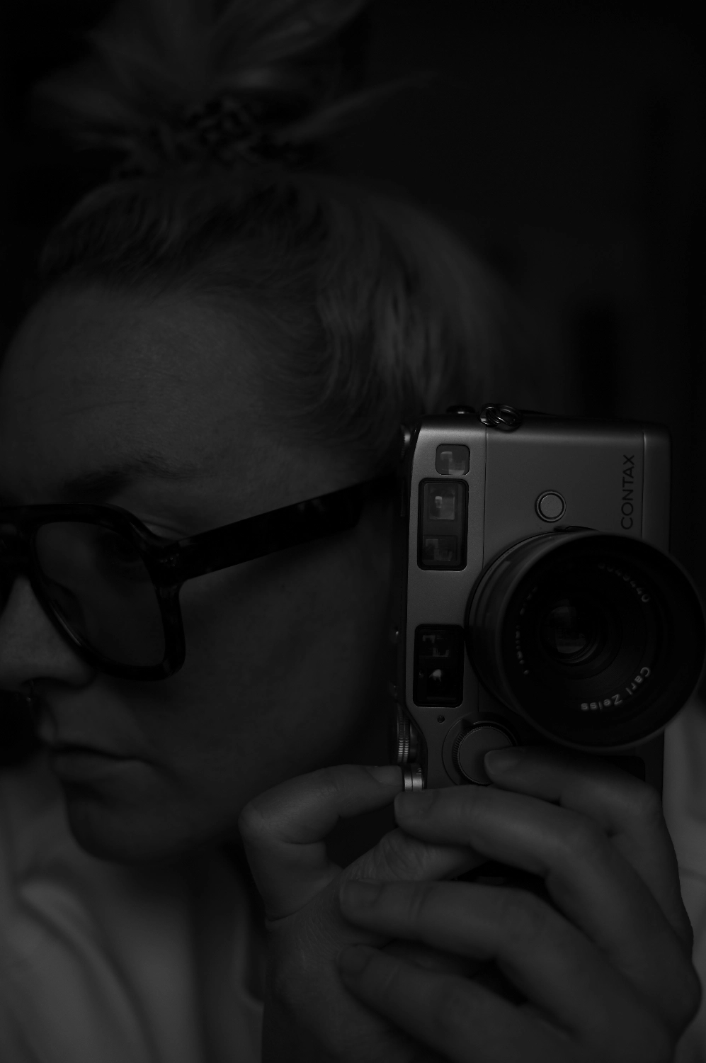 moderne-brand-fotografie-stuttgart-fotografin-mit-kamera-portrait Moderne Brand Fotografie in Stuttgart: Nahes Portrait einer Fotografin mit Brille und Kamera in dunkler, editorialer Inszenierung.