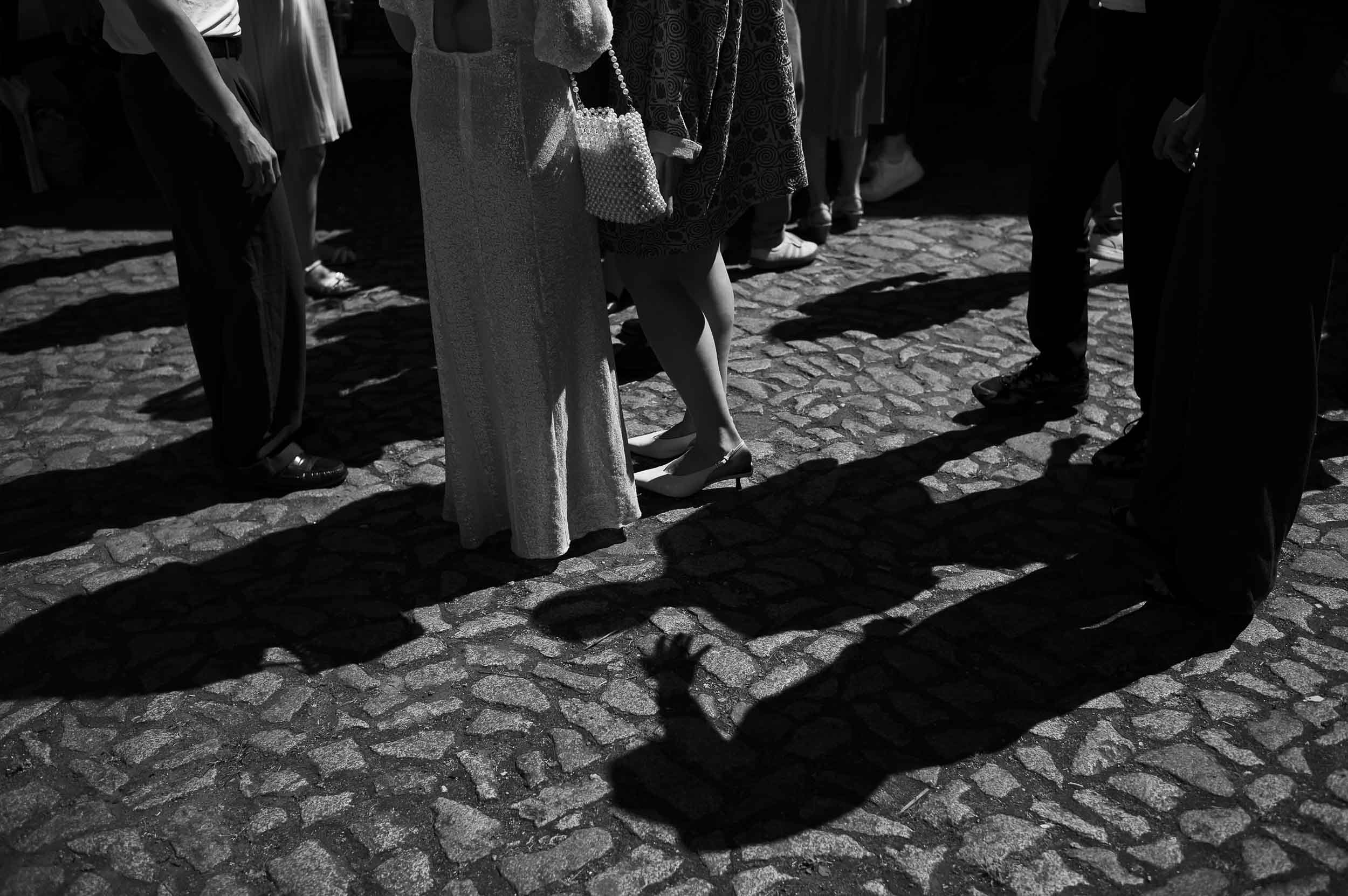 berlin-hochzeit-civil-wedding-editorial editoriales schwarzweißfoto von hochzeitsgästen und ihren schatten im sonnenlicht bei einer hochzeit in berlin