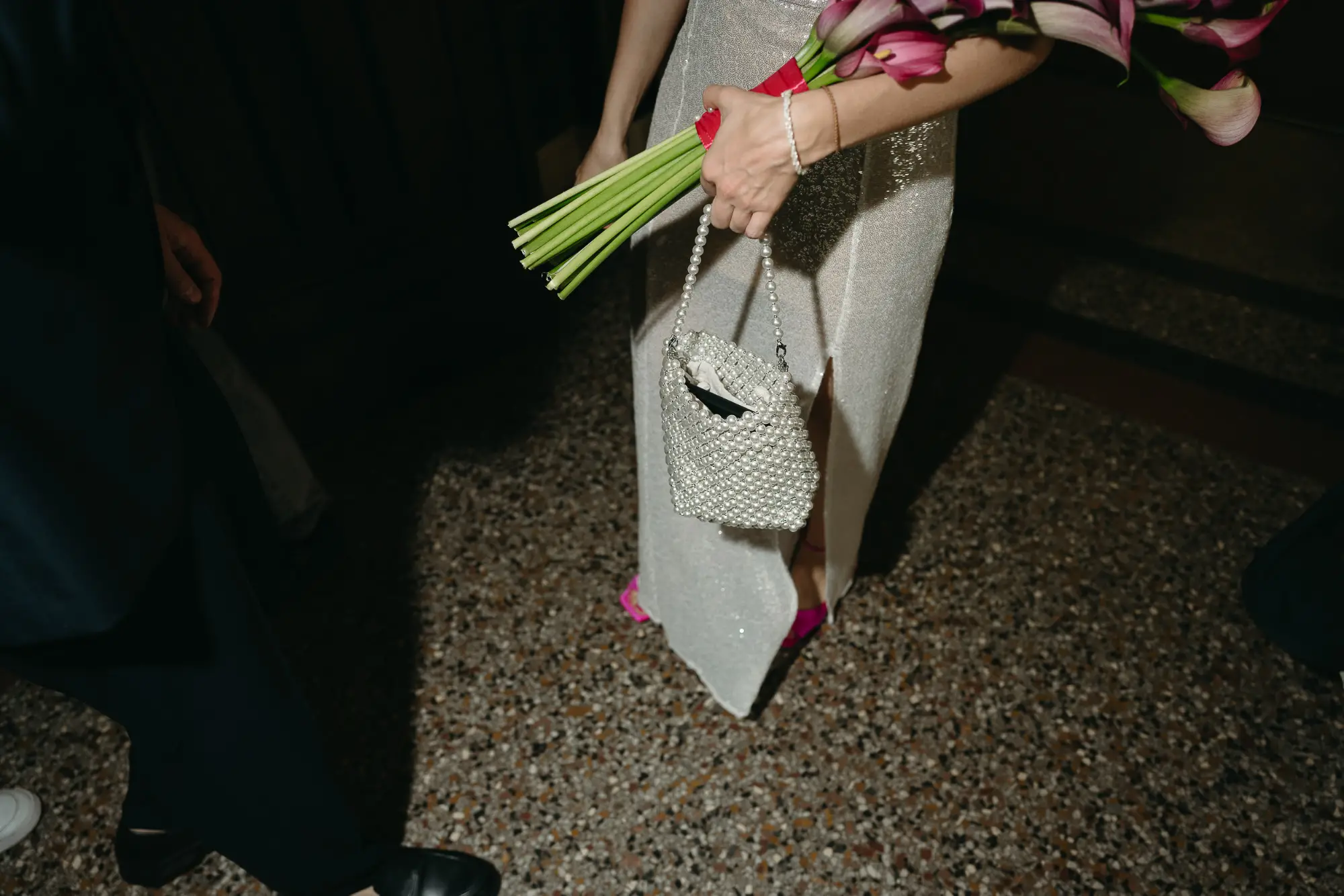 braut-details-calla-hochzeit-berlin editoriales brautdetail mit pinken calla blumen, perlenhandtasche und silbernem brautkleid bei einer hochzeit in berlin